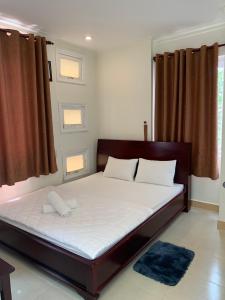 伊缇天福Nhu Ngoc Homestay的卧室配有一张带白色床单和枕头的大床。