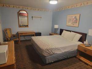 格兰茨帕斯Sweet Breeze Inn的一间卧室配有一张床、一张书桌和一面镜子