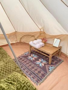 Kon Von KlaCOI NGUON FARM GLAM Mang Den的帐篷配有一张床和一张桌子
