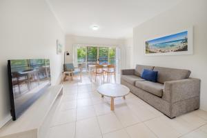 萨拉曼德湾Oaks Port Stephens Pacific Blue Resort的客厅配有沙发和桌子