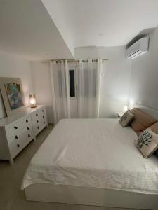 泰尔斯贝斯Coco Lodge的白色卧室设有一张大床和一个梳妆台