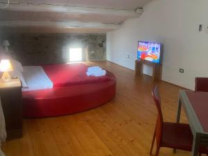 Marano MarchesatoIl Casale的一间卧室,卧室内设有一张红色的大床