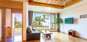 济州市和谐度假村的带沙发和大窗户的客厅