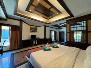 高兰Beach Bungalow at Lanta Resort的一间卧室配有一张大床和两条毛巾