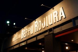 别府BEPPU ROJIURA stay&sauna的夜间建筑物一侧的标志