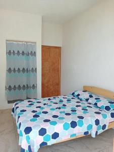 La SabrosaCasa Laud Chacahua的一间卧室配有一张带蓝色和白色棉被的床