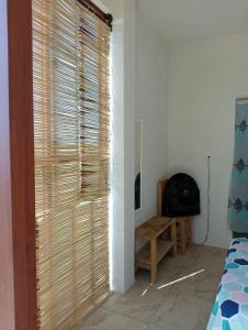 La SabrosaCasa Laud Chacahua的客房设有带木制百叶窗的大窗户。