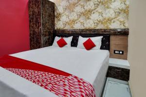 巴特那OYO Flagship Hotel Prince Inn And Banquet Hall的红色卧室配有白色的床和红色枕头