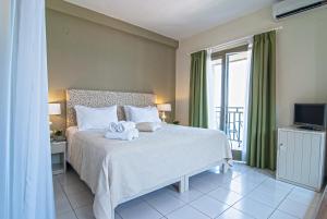 阿吉奥斯伊欧尼斯Kenta Beach Hotel的一间卧室配有一张床,床上有毛巾