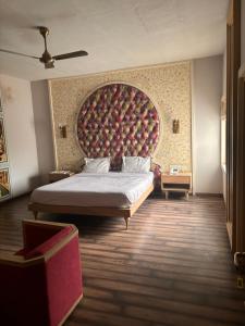 斋浦尔Hotel MEHAI HOUSE的一间卧室配有一张大床和大床头板