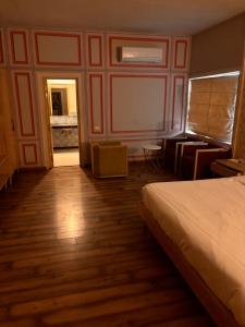 斋浦尔Hotel MEHAI HOUSE的酒店客房带一张床铺、一张书桌和一间卧室