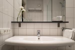 马斯特里赫特奥阔提尔酒店的白色的浴室设有水槽和镜子