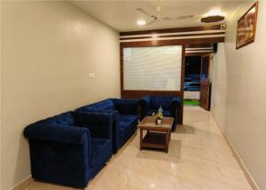 浦那Shrinidhi Residency Pune的客厅配有蓝色的沙发和咖啡桌