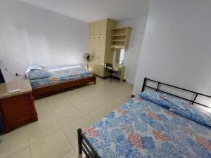 麦克坦Vacation Town House Near Mactan Cebu Airport的一间卧室配有两张床和一张书桌