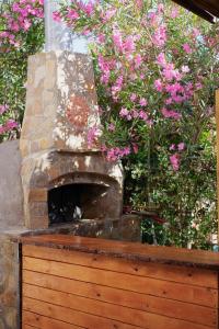 KumlucaLb Boutique Hotel的花园内带粉红色花卉的石头壁炉