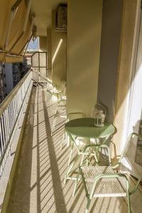 雅典Apartment in the heart of the city的阳台上配有绿色的桌椅