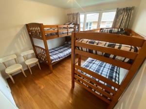 罗托鲁瓦Rotorua Forest Getaway的配有两张双层床的客房配有桌椅