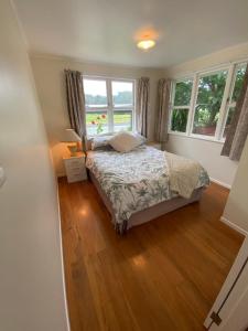罗托鲁瓦Rotorua Forest Getaway的一间卧室设有一张床和两个窗户。