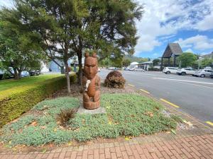 罗托鲁瓦Rotorua Forest Getaway的坐在街道边的雕像
