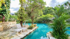 梭罗洛林索罗酒店的庭院里一个带两把椅子和树木的游泳池