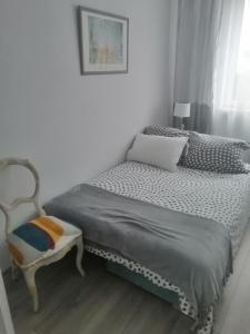 科沃布热格Apartament szafirowa25 pietro1的一间小卧室,配有一张床和一把椅子