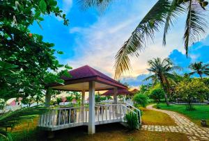 OtonRedDoorz @ Padi Beach Resort Oton Iloilo的棕榈树公园的凉亭