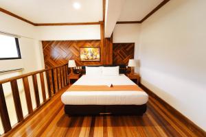 卡兰巴煦日和风温泉度假山庄的铺有木地板的客房内设有一间卧室和一张床。