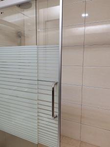 山打根Hotel Prima的浴室里设有玻璃门淋浴