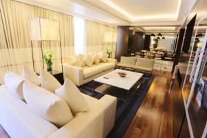卡拉奇卡拉奇阿瓦里塔酒店的客厅配有白色的沙发和桌子
