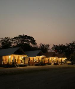 素攀武里อิงน้ำท่าจีน (ท่าจีนรีสอร์ท)的一群帐篷在晚上在田野里