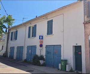 土伦Ancien appartement de pêcheur的白色的建筑,街道上设有蓝色的门