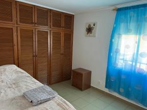 梅利利亚Piso cerca de la playa.的一间卧室配有一张床和一个木制衣柜