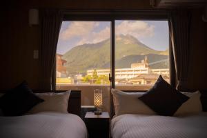 由布市Tabi no yado Hanakeshiki Momo 4th floor - Vacation STAY 42997v的酒店客房设有两张床和大窗户。