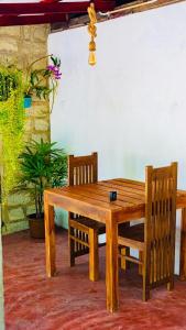 阿杭格默Ostello Surf Resort的一张木桌和两把椅子,一张桌子和一株植物
