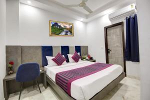 新德里Hotel S B INN Paharganj的一间卧室配有一张大床和一张蓝色椅子