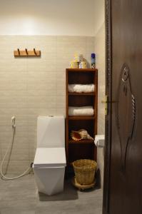 PanganiLui Ushongo Beach House的一间带卫生间的浴室和一个带毛巾的架子