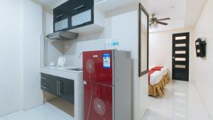 宿务RedDoorz at Grand Apartelle Hernan Cortes Cebu的一间厨房,在房间内配有红色冰箱