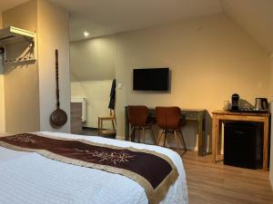 布鲁日兰花旅馆的酒店客房设有一张床和墙上的电视