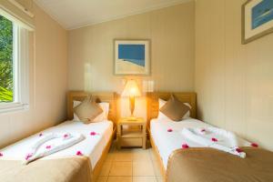 Turtle CoveKokomo Botanical Resort - Caribbean Family Cottages的一间卧室配有两张鲜花床。