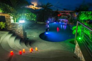 Turtle CoveKokomo Botanical Resort - Caribbean Family Cottages的夜间游泳池,有红灯