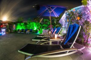 Turtle CoveKokomo Botanical Resort - Caribbean Family Cottages的一排带遮阳伞和灯的躺椅