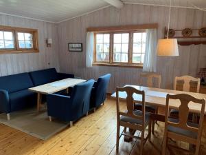 EidsbugardenTyinholmen Høyfjellsstuer的客厅配有桌子和蓝色椅子