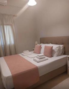 普拉蒂Odyssey's Feats的卧室配有带粉色和白色枕头的大床