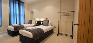伊普斯威奇Modern 2 bedrooms apartment in Town centre的两张位于酒店客房的床,配有蓝色窗帘