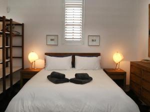 斯坦福40 on Longmarket的一间卧室配有一张带两盏灯的大型白色床。