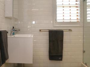 斯坦福40 on Longmarket的浴室设有白色水槽和黑色毛巾。