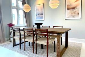 哥本哈根2 Bedroom Flat in Trendy Area的一间带木桌和椅子的用餐室