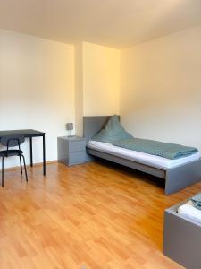 新乌尔姆Apartment über Neu Ulm's Dächern, 2 Schlafzimmer inkl. Stellplatz的一间卧室配有一张床和一张书桌