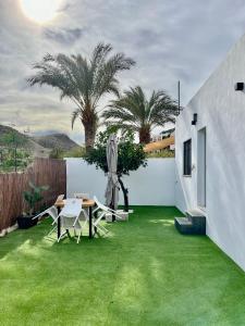 拉斯内格拉斯Villa Don Paco的后院拥有绿色的草地和桌椅
