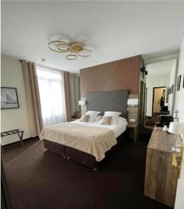 康布雷Logis Hôtel & Restaurant - Le Mouton Blanc的一间卧室设有一张大床和一个大窗户
